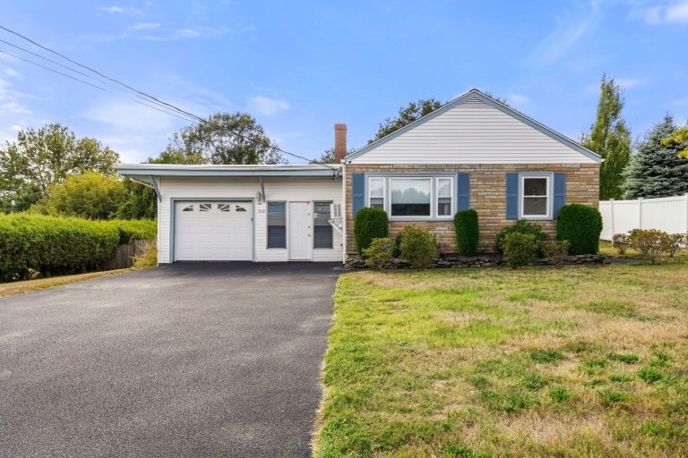 Front view of 1845 Main Street in Brockton showcasing ranch-style home with attached garage and manicured shrubs.